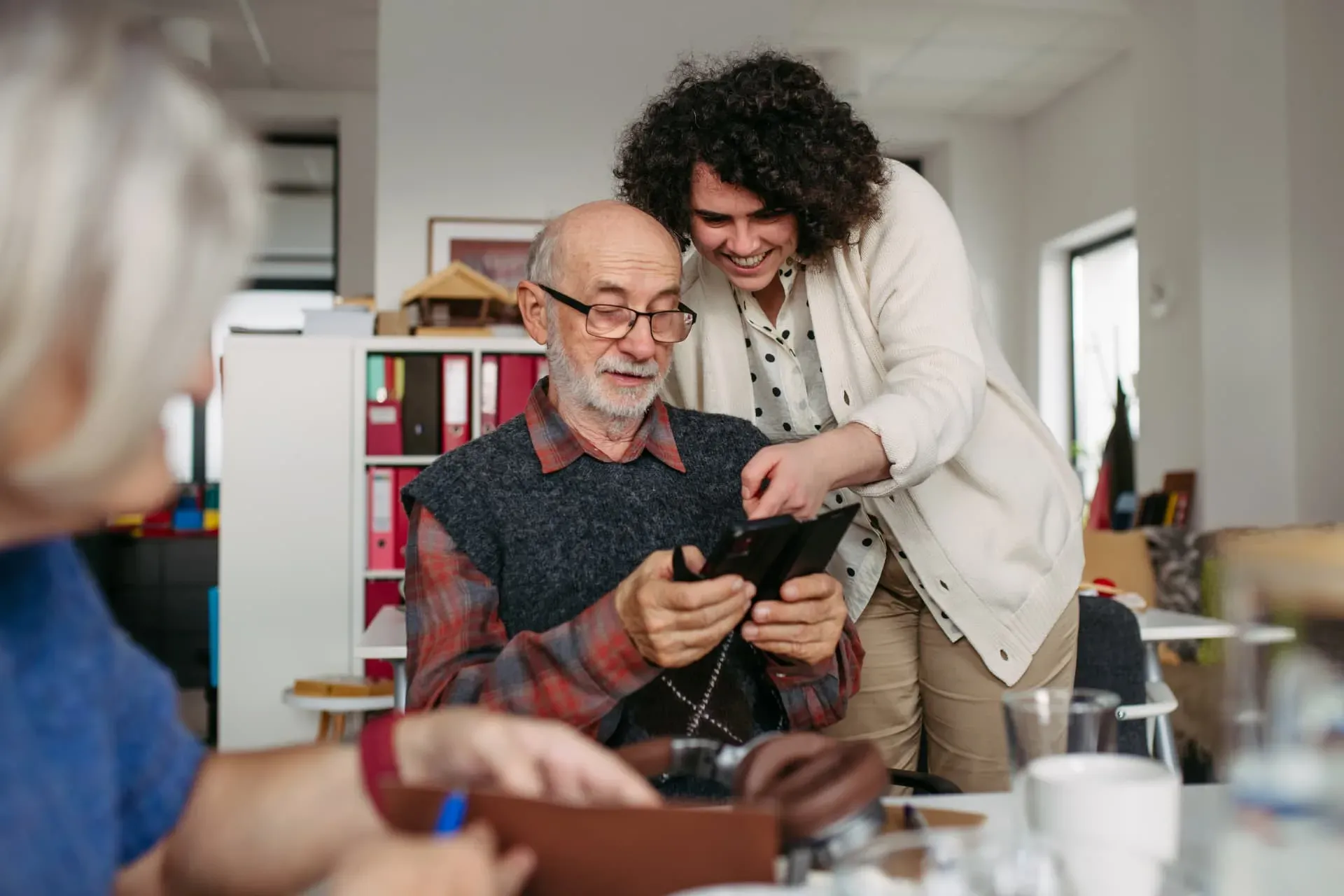 A caregiver helping an older adult use a smartphone